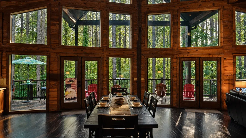 Great room with a wall of windows facing the pines